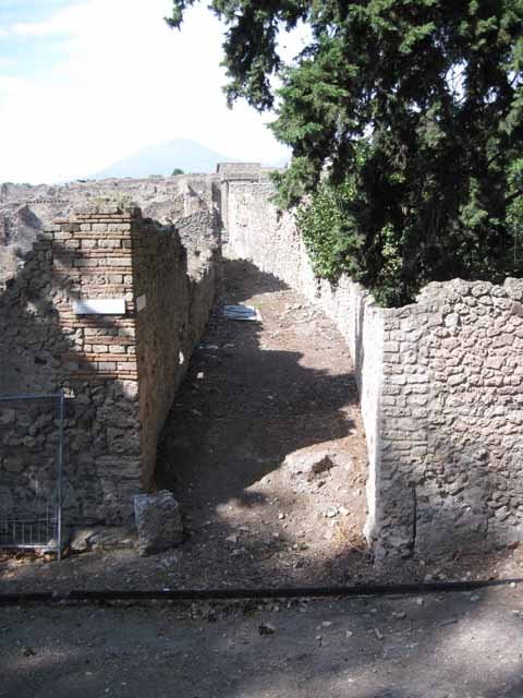 Pompeii. Street altar near I.1.10, looking west. September 2010. Photo courtesy of Drew Baker. According to Sogliano, on the south-east corner of the insula was a small masonry altar. The altar was covered with red stucco, and the wall behind was also painted. On this wall were two very large serpents crawling between plants, one on each side of the corner of the insula. Today, there is no visible trace, other than the red stucco at the base of the altar, above. See Sogliano, A., 1879. Le pitture murali campane scoverte negli anni 1867-79. Napoli: (p.9)