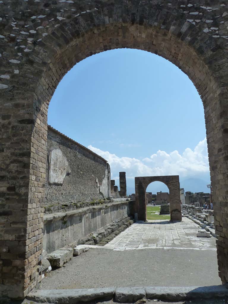 Arched entrance in north-west corner of Forum. May 2010. 
Looking south through arch towards the Arch of Augustus.
