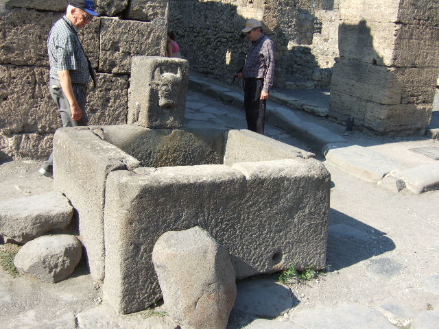 Fountain outside VI.13.7. May 2006. Large lava stones on west side of fountain.