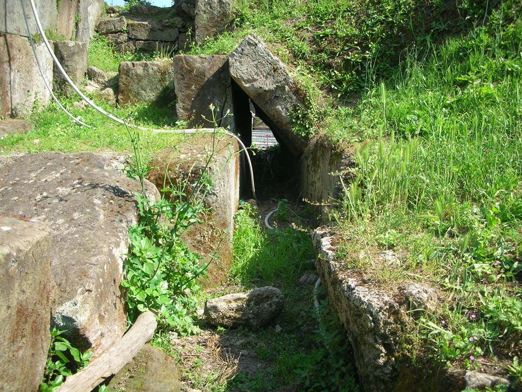 Porta di Nocera or Nuceria Gate, Pompeii. May 2010. 
Looking south along course of drain on west exterior side of gate. Photo courtesy of Ivo van der Graaff.
According to Van der Graaff –
“The drains are less conspicuous and a practical necessity. 
Even today, the characteristic sudden downpours of the region can turn the streets into small torrents draining water from much of the city. 
Each gate on the downslope side of Pompeii was a natural drain because they tend to be on the topographical depressions that formed the easiest access routes into the city. Rather than having the water pass through the gates, authorities eventually built formal drains through the agger. 
At Porta Stabia, Nocera and Sarno, engineers would modify basalt street pavers to direct runoff waste into the sewers passing next to the gate to keep the passageways free of wastewater (Note 110). …………………….
Most gates indicate that drainage concerns were already current in the late second century BCE, if not earlier. 
The Porta Nocera preserves a drain on its western flank. 
Due to its relative height, it clearly predates the lowering of the road passing through it – an event that occurred in the Augustan period. 
The drain remained in use as engineers altered the flagstones in the road to channel the water into the sidewalk farther uphill (Note 115).”
See Van der Graaff, I. (2018). The Fortifications of Pompeii and Ancient Italy. Routledge, (p.103-104, Notes 110 and 115).
