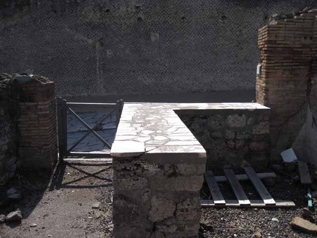 I.2.13 Pompeii. September 2005. Taken from rear. Looking west towards site of ruined small rear room or cupboard, and bar-room onto Via Stabiana and the Little Theatre. On the left, behind the brick pilaster separating two doorways, would have been the site of the south wall of I.2.13. I.2.14 is visible on the extreme right of the picture.