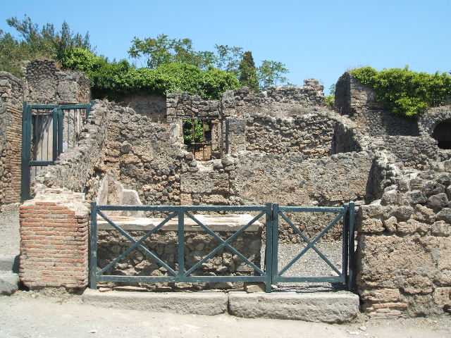 I.3.2 Pompeii. December 2005. Counter, with four large terracotta dolia and display shelves. Looking north. According to Boyce, there was a niche in the north wall but it was in a ruinous state. See Boyce G. K., 1937. Corpus of the Lararia of Pompeii. Rome: MAAR 14. (p.23)