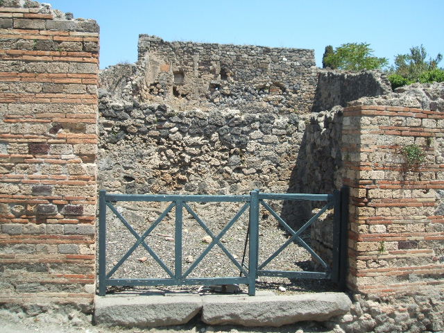 I.3.7 Pompeii. September 2010. South wall of shop, with brick podium in south-west corner.
Photo courtesy of Drew Baker.