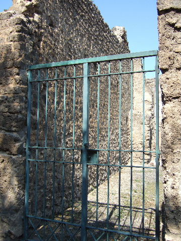 I.8.13 Pompeii. September 2005. Looking north-east from entrance, towards rear of house. According to Della Corte, in a cubiculum on the south-east side of the inner courtyard, interesting graffiti were found –
See Della Corte, M., 1965.  Case ed Abitanti di Pompei. Napoli: Fausto Fiorentino. (p.327) 
Idibus Iulis inaures pos(i)tas ad Faustilla(m).
Pro denariis II deduxit aeris a(ssem).
Ex sum(ma) XXX     [CIL IV 8203]
According to Epigraphik-Datenbank Clauss/Slaby (See www.manfredclauss.de) this read as –
Idibus Iuli(i)s 
inaures postas ad Faustilla(m) 
pro |(denariis) II usura(m) deduxit aeris a(ssem) 
ex sum(ma) XXX                      [CIL IV 8203] 
According to Cooley, this was found to the right of CIL IV 8204, in the south-east corner of the bedroom.
She translated it as –
“15 July.  Earrings deposited with Faustilla. Per two denarii she took as usury one copper as.  From a total? 30.”   [CIL IV 8203]  
See Cooley, A. and M.G.L., 2004. Pompeii : A Sourcebook. London : Routledge. (p.170)
According to another book, it translated as -
“On July fifteenth I pawned earrings to Faustilla for 2 denarii (equivalent to 32 asses). From this amount, she deducted one-thirtieth as interest for the monthly usury of one as”     [CIL IV 8203]  
See Panetta, M. R. (ed). 2004. Pompeii, the history, life and art of the buried city. Italy, White Star Publishers; (p. 231)

IV non(as) Iul(ias) paenulam palliolum [posita ad Fau]stillam Pr[oden.]
L [deduxit ?] XIII semis ( ?).
[Aeri]s a(sses) VIII     [CIL IV 8204]
According to Epigraphik-Datenbank Clauss/Slaby (See www.manfredclauss.de) this read as –
IV Non(as) Iul(ias) 
paenulam palliolum [posita ad Fau]stilla(m) 
pr[o |(denariis)] L usur[a] 
[deduxit] XIII s(emissem) 
[aeri]s a(sses) VIII       [CIL IV 8204]
According to Cooley, this was found in the south-east corner of the bedroom.
She translated it as –
“4 July. Hooded cloak and small cloak (deposited by Fau)stilla. Per 50 (…)usury (…) 14 and a half (…) 8 asses”.   [CIL IV 8204]
See Cooley, A. and M.G.L., 2004. Pompeii : A Sourcebook. London : Routledge. (p.170)
The other book describes it as another graffito found in the same room but written just a few days earlier on July 4th.
This time Faustilla received another bitter pledge, this time a cape with a hood.
See Panetta, M. R. (ed). 2004. Pompeii, the history, life and art of the buried city. Italy, White Star Publishers; (p. 231)

