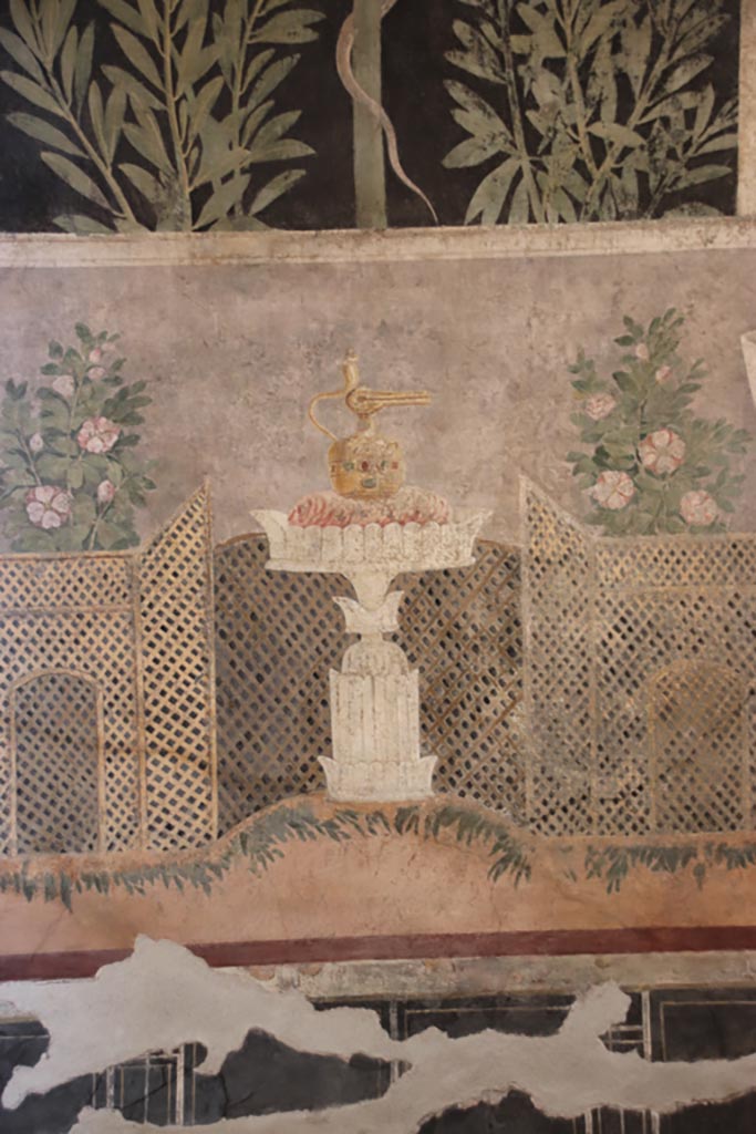 I.9.5 Pompeii. October 2022.  
Room 11, centre of east wall of cubiculum with garden painting with lattice fencing and table with Isis jug or jar.
Photo courtesy of Klaus Heese.


