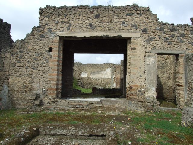 I.9.12 Pompeii. March 2009. Room 1, atrium. Remains of steps on south side of tablinum.