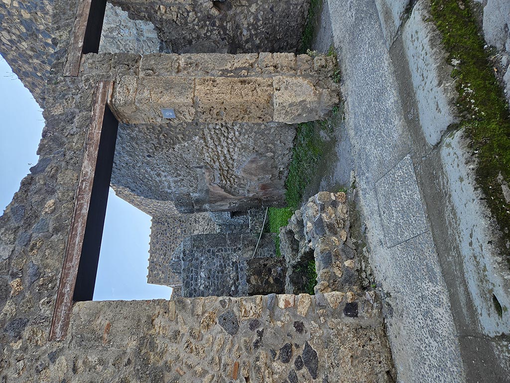 I.10.2 Pompeii. December 2006. West wall of caupona, and site of stairs to upper floor.  According to Della Corte, found to the right of the entrance in very small writing was a set of questions and answers between two rivals in love. Their names were Severus and Successus.  [CIL IV 8259-58] See Della Corte, M., 1965.  Case ed Abitanti di Pompei. Napoli: Fausto Fiorentino. (p.292)
According to Epigraphik-Datenbank Clauss/Slaby (See www.manfredclauss.de), these read as –
Successus textor amat coponiaes ancilla(m) 
nomine Hiredem quae quidem illum 
non curat sed illa com(m)iseretur 
scribit rivalis   vale 
invidiose quia rumper<i=E>s se<c=D>are noli formonsiorem 
/ 
et qui est homo prav<i=E>ssimus et bellus           [CIL IV 8259]
Dixi scripsi amas Hiredem 
quae te non curat SIX() Successo 
ut su[p]ra(t) [3]s[3] 
Severus                                                                           [CIL IV 8258]
According to Cooley, this the love story of Successus, Severus and Iris played out on the walls of the bar. [CIL IV 8258, 8259]
There are 3 messages, the first and third by Severus, the second is the reply of Successus.  These translate as -
(Severus)  -  “Successus, a  weaver, loves the innkeeper’s slave girl named Iris, She, however, does not love him.  Still he begs her to have pity on him. His rival wrote this.  Goodbye” 
(Answer by Successus)  - “Envious one, why do you get in the way. 
 Submit to a handsomer man and one who is being treated very wrongly and good looking” 
(Answer by Severus) -  “I have spoken. I have written all there is to say. You love Iris, but she does not love you”.
See Cooley, A. and M.G.L., 2004. Pompeii : A Sourcebook. London : Routledge. (p.77-78) 

  
