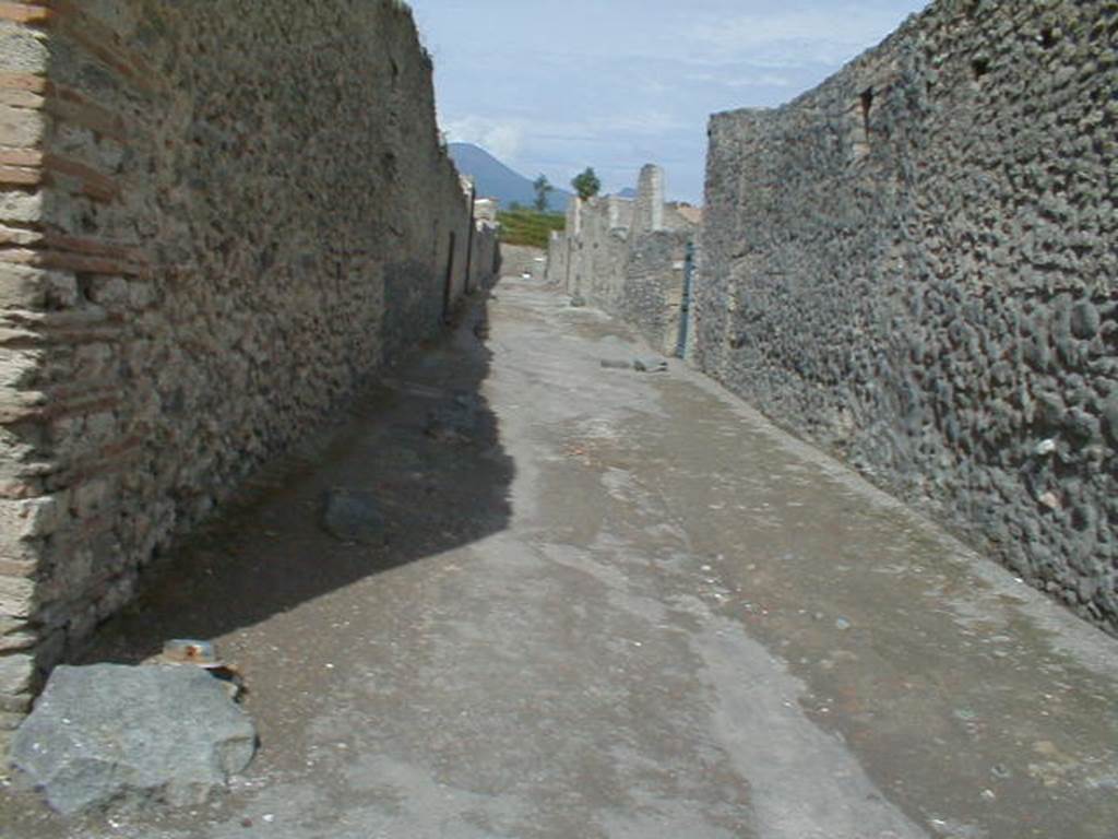I.12 Pompeii. September 2004. Vicolo dei Fuggiaschi looking north.Side wall of  I.13.13

