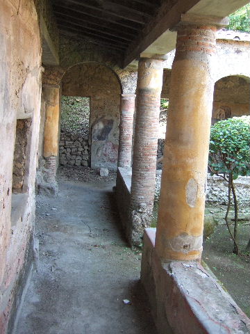 I.17.4 Pompeii. May 2006. Looking west along south portico.
At the far end can be seen the site of a staircase (now filled in again).