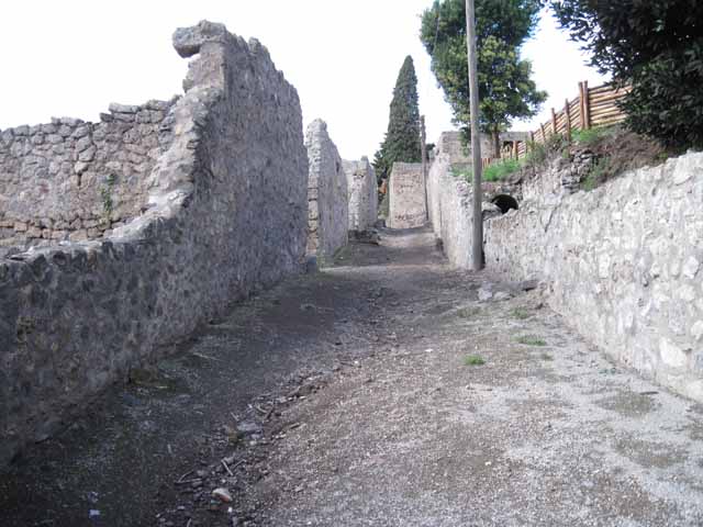 I.2.22 Pompeii. September 2010. Looking south to restored south end of insula I.19, into the unexcavated, on the east side of Vicolo del Citarista.
Photo courtesy of Drew Baker.