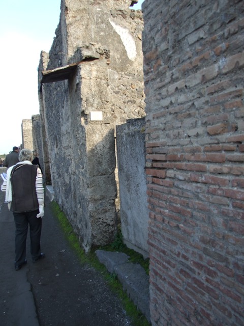II.3.2 Pompeii. March 2009. Rear of plaster cast of doors, and II.3.1 entrance to stairs to upper floor, on north wall.