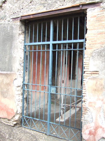 III.4.b Pompeii. December 2005. Entrance with remains of painted plaster on either side.