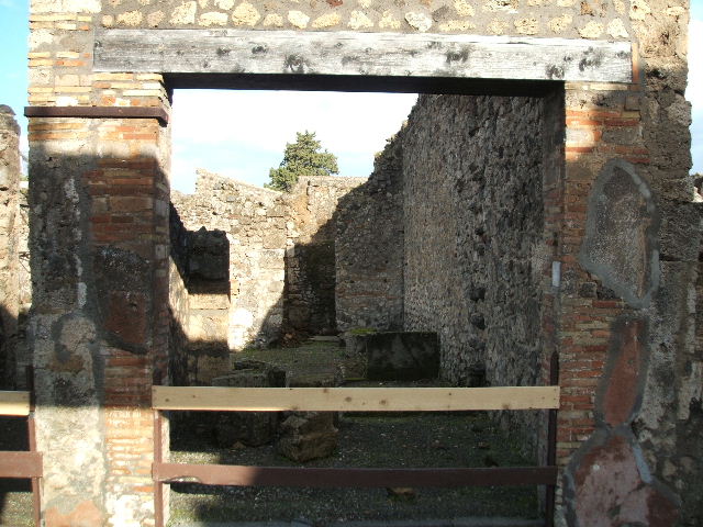 V.I.16 Pompeii. December 2006. Bakery shop, looking towards south wall of shop and atrium of V.1.15 to rear.   