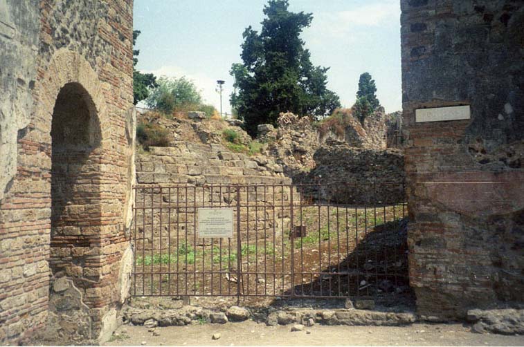 VI.1.1 Pompeii. Entrance. Photographed 1970-79 by Günther Einhorn, picture courtesy of his son Ralf Einhorn.
According to Garcia y Garcia, this inn, sheltered by the city walls and with a beautiful well-preserved sacellum, was hit by a bomb during the night of 14th to 15th September 1943. It was nearly completely destroyed, even its perimeter wall. The dividing wall to the peristyle of the House of the Vestals also fell. By September 1982, the entrance steps and its internal walls were reduced to a ruined pile. To the west of this house, the same bomb destroyed also part of the beautiful Samnite steps, that permitted access to the public wall. At the foot of it, in the public area, was a well-known well. See Garcia y Garcia, L., 2006. Danni di guerra a Pompei. Rome: L’Erma di Bretschneider. (p.66)