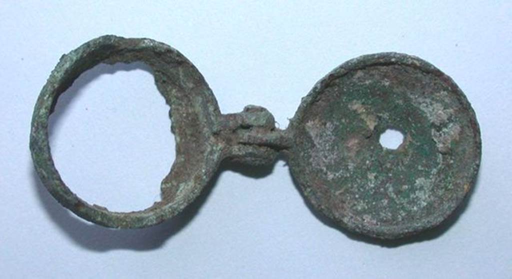 VI.9.1 Small bronze object with a mortise and a pin with a circular element whose bottom is torn off. Side 1. Height 0.008m, diameter 0.016m.  OA 2030 Petit lment articul, muse Cond, photo RMN  R.G. Ojeda