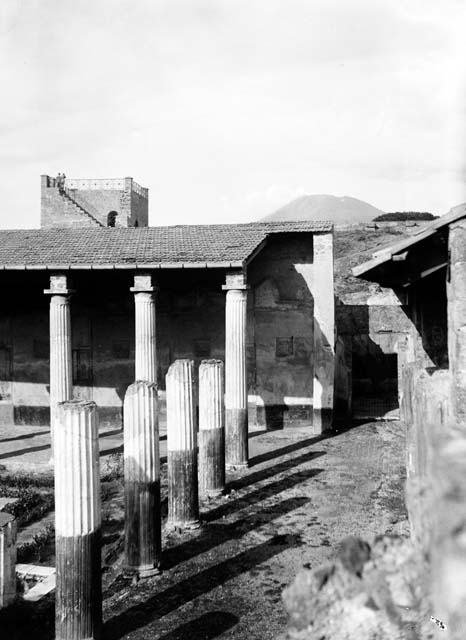 VI.9.2 Pompeii. September 2004. Peristyle 16, fountain and pool, looking west. According to Jashemski, the large and elaborate pool had its interior painted blue. The interior walls were bordered with alternate rectangular and semicircular recesses. A column in the centre of the pool supported a round table, from which water jetted and fell into the pool.
There is a small pool with a marble rim at the east end, together with a small basin adjacent to the large pool on the west side. The small basin may have been used for storing the fish while the pool was cleaned, or perhaps for cooling drinks. See Jashemski, W. F., 1993. The Gardens of Pompeii, Volume II: Appendices. New York: Caratzas. (p.137-38)
