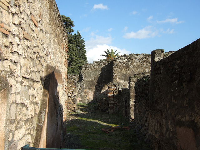 VI.10.4 Pompeii. March 2009. Triclinium at rear of house, with rear entrance at VI.10.18, taken from garden area. Looking east. The corridor is on the left of the photo, next to it was a window in the west wall of the triclinium.
This would have been the window Jashemski said looked out onto the garden area.
