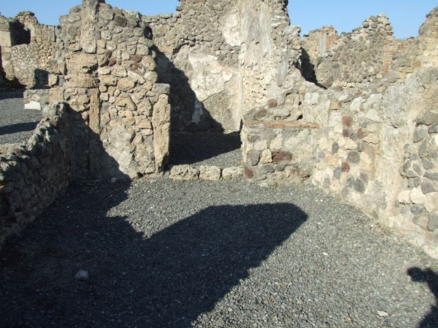 VI.14.3 North wall with stove in north east corner and doorway to rear room.