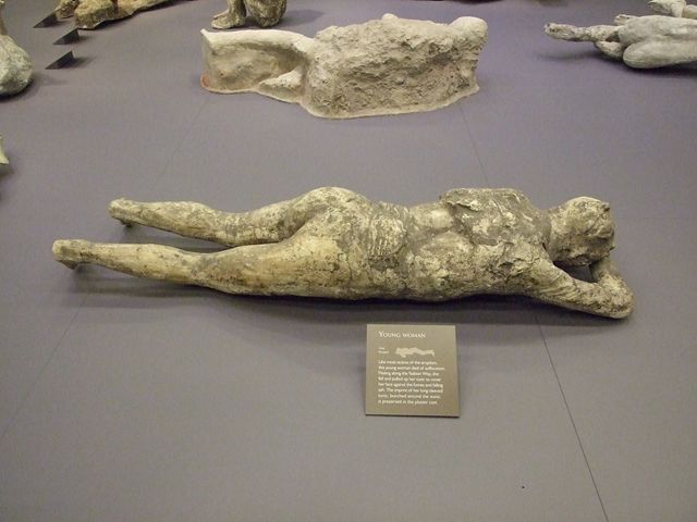 Plaster cast of a supine man with arms and legs slightly contracted, wrapped in a cloak. He was found next to the woman with her tunic raised over her head. Found 23rd April 1875 in north-east corner of VI.14 in middle of Via Stabiana, four metres above ground level in the ash layer. Photo courtesy of Rick Bauer