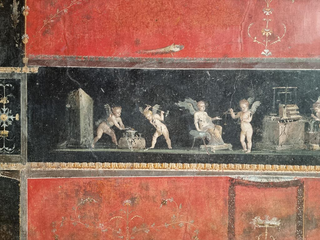 VI.15.1 Pompeii. December 2023. East wall with detail of part of painting of cupid goldsmiths. Photo courtesy of Miriam Colomer.