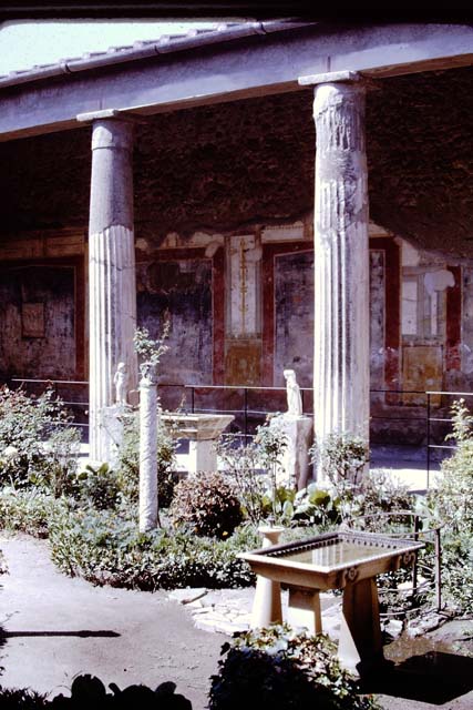 VI.15.1 Pompeii. December 2006.   Detail of painted pillar between Peristyle and Atrium with figure holding a cup.
