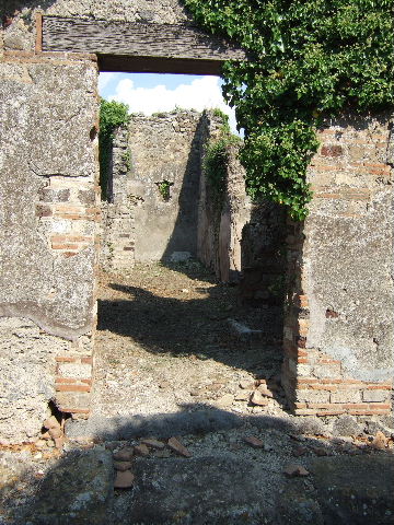 VI.15.22 Pompeii. September 2005. Looking east towards entrance doorway. According to Della Corte, the name on an amphora with its contents which was found here, was –
Cinnio Fortunato.  
See Della Corte, M., 1965.  Case ed Abitanti di Pompei. Napoli: Fausto Fiorentino. (p.62)
According to Epigraphik-Datenbank Clauss/Slaby (See www.manfredclauss.de), it read -
Lac bes lixa vet(us) 
summa(rum) 
AAA 
CXL 
C(ai) Terenti Paul(li) 
/ 
Cinnui fort 
/ 
LXXXIV s(emissem)       [CIL IV 5648]
