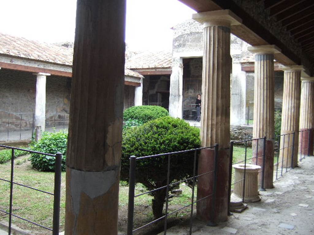 VI.16.7 Pompeii. December 2004. Peristyle garden F, looking south-west from north-east corner. According to Jashemski – The two pilasters supporting a pediment on the west side of the peristyle were white and fluted. The other columns were white and fluted above, but were painted red, and smooth below. The corner columns on the east side, together with the fourth column from the east, on the south and north sides, were painted yellow below.
See Jashemski, W. F., 1993. The Gardens of Pompeii, Volume II: Appendices. New York: Caratzas. (p.159).
