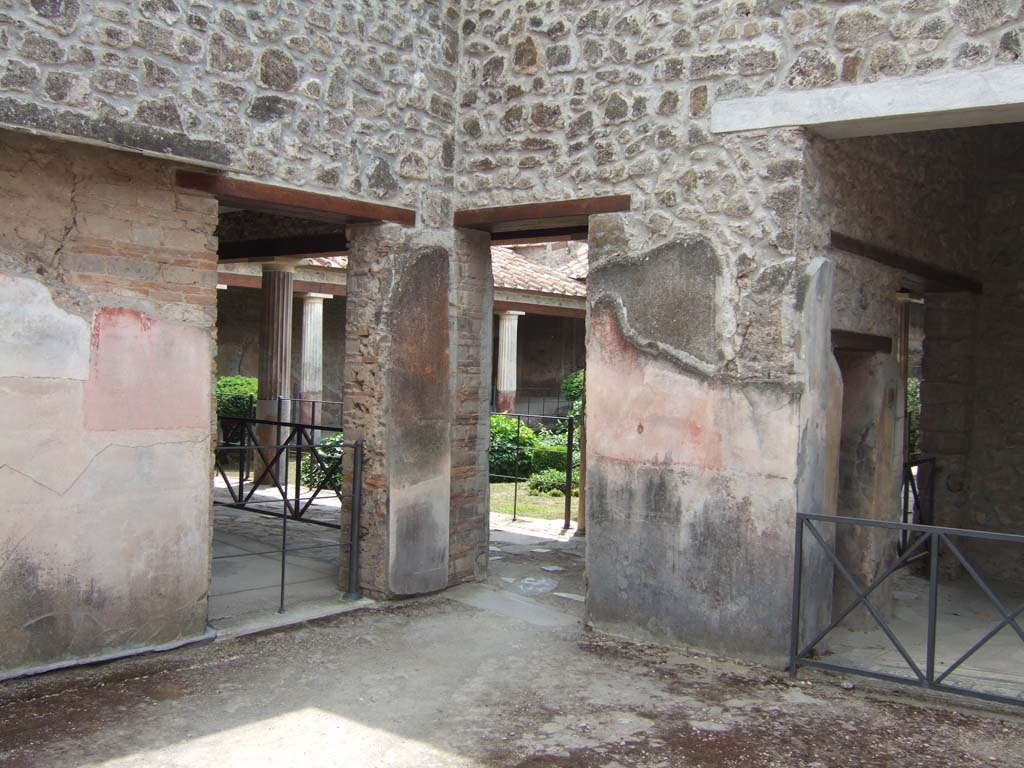 VI.16.7 Pompeii. May 2006. South-west corner of room B, atrium.
Looking towards side doorway into room G, on left, doorway to portico, in centre, and to room E, on right.
