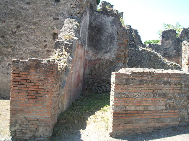 VI.16.20 Pompeii. May 2005. The entrance doorway of VI.16.20 is in the wall on the left. Photo taken from VI.16.23. Looking south.
