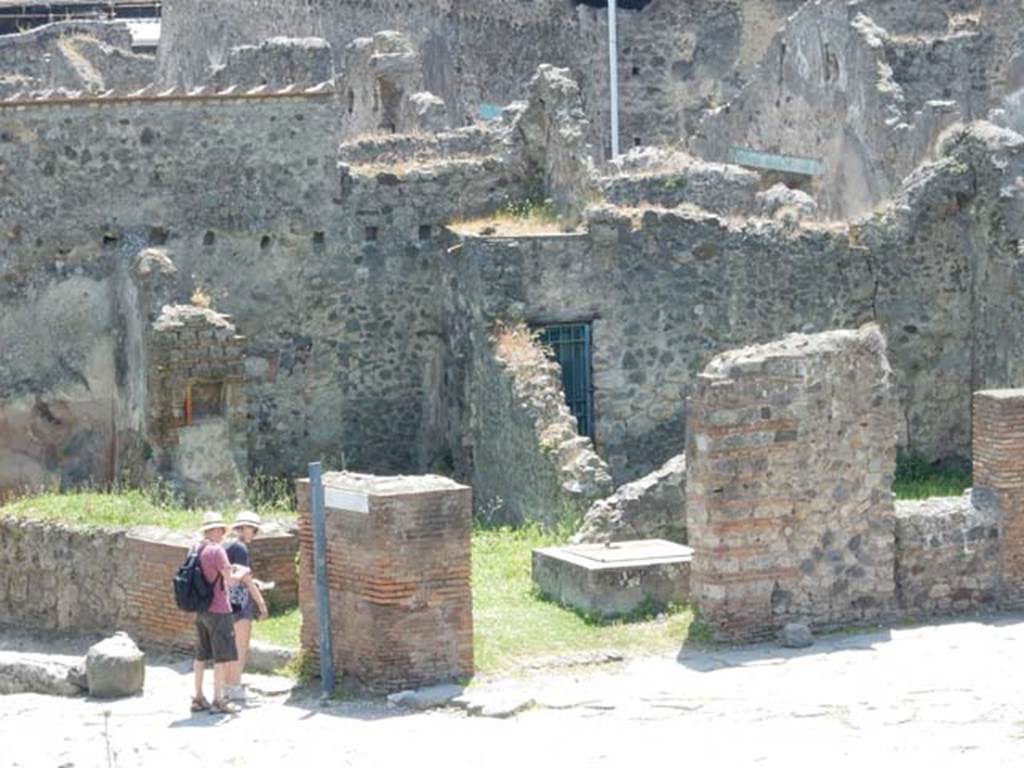 VI.16.21 Pompeii.  May 2015. Entrance doorway with two tourists about to enter. VI.16.22 is in the centre of the photo. Photo courtesy of Buzz Ferebee.
