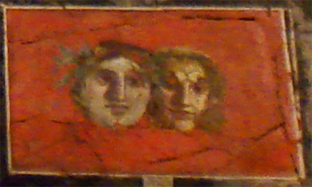 VI.17.42 Pompeii. Oecus 32. Detail of two faces from upper part of east wall. Parco Archeologico di Pompei, inventory number 40691.