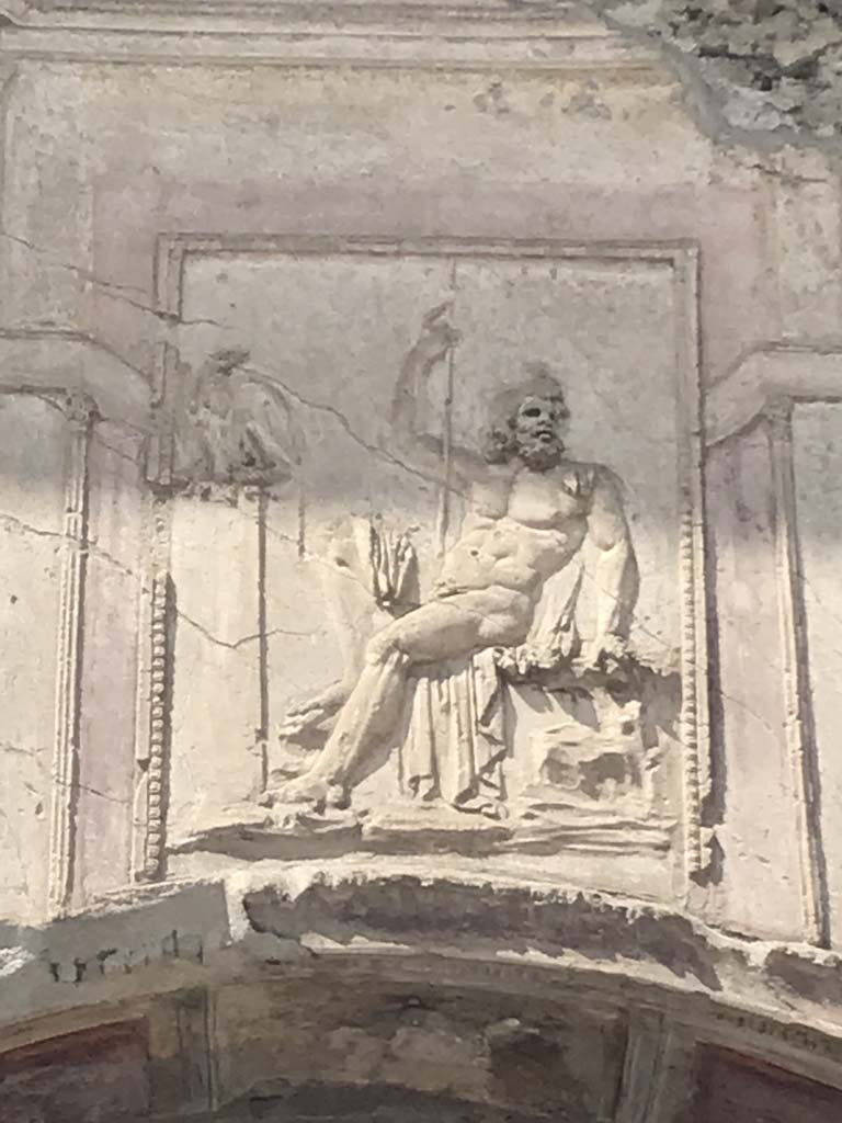 VII.1.8 Pompeii. April 2019. Detail of stucco relief of a seated Zeus, above arch of nymphaeum F. 
Photo courtesy of Rick Bauer. 
