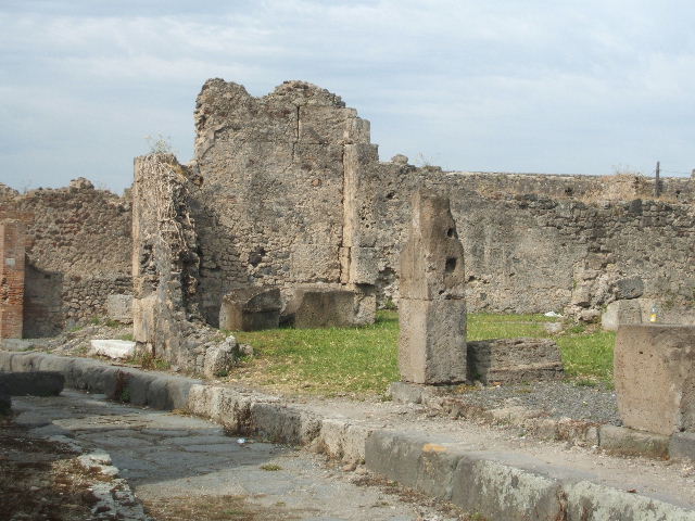VII.6.28 Pompeii. September 2005. Entrance with white marble sill. 
Looking north-west towards site of cubiculum on west side of entrance corridor, which was destroyed by bombing.
According to Fiorelli, this house only had the entrance and fauces excavated (by 1873).
On the stucco on the front of the house, there were the remains of the graffiti:
C(aium)  Cuspium  Pansam
a[ed](ilem)  d(ignum)  r(ei)  p(ublicae)      [CIL IV 542]
and painted in large letters in red –
Secundus Tyran(n)us Fortunatus    [CIL IV 543]
See Pappalardo, U., 2001. La Descrizione di Pompei per Giuseppe Fiorelli (1875). Napoli: Massa Editore. (p.160)
See Epigraphik-Datenbank Clauss/Slaby (See www.manfredclauss.de)

