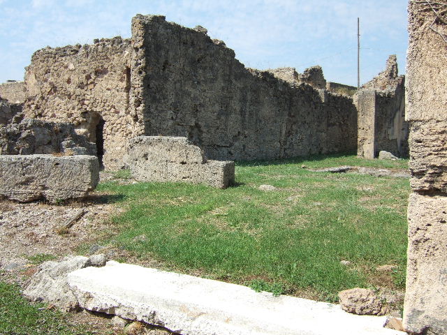 VII.6.28 Pompeii. About 1910  South-west corner of the peristyle.  
In the picture can be seen a low wall or threshold of the tablinum, the andron and the doorway to room 7.   Also visible is a masonry altar.  This area was devastated by bombing in 1943.  Photograph courtesy of Soprintendenza Speciale per i Beni Archeologici di Napoli e Pompei.  Negative number C369.

According to Boyce, near the south-west corner of the peristyle stood a rectangular masonry altar, coated with stucco. On the top of it, traces of burning were visible at the time of excavation. He also said that holes found in the earth near the altar were explained by Spano (Not.Scavi) as being the decomposed roots of a large tree. Spano thought this may have been an arbour sacra, which may have been honoured by sacrifice upon the altar. See Boyce G. K., 1937. Corpus of the Lararia of Pompeii. Rome: MAAR 14. (p.67, no.291)  Not.Scavi, 1910, 466f and fig.9,9a. 
