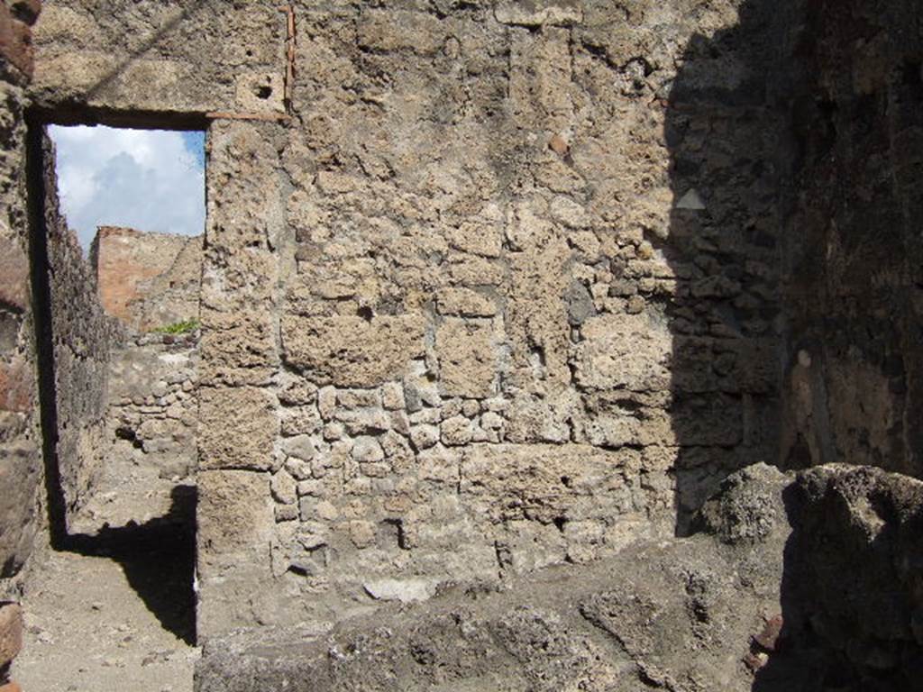 VII.7.11 Pompeii. September 2004.  North wall with doorway to rear room, (behind entrance at VII.7.12 ), with corridor to rear. 
