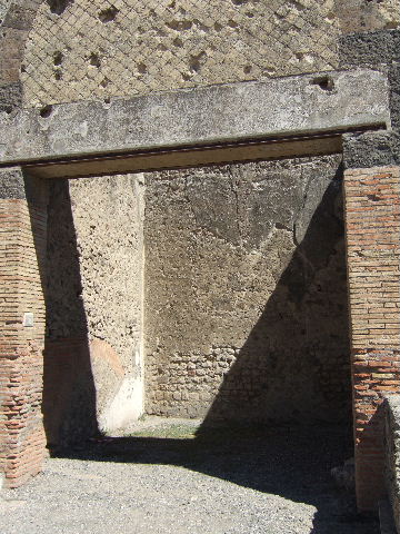 VII.9.10 Pompeii. Shop. December 2007. North wall and statue base with remains of marble.