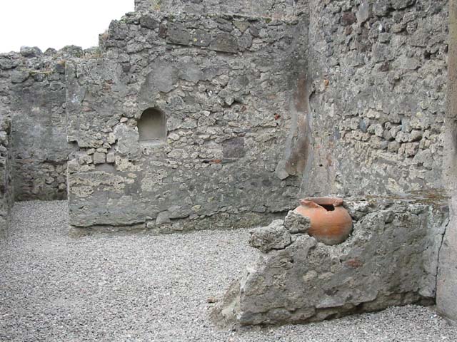 VII.9.49 Pompeii.  December 2005. According to L Eschebach there was a two sided counter with two urns of which one remains.  Is this the terracotta pot shown here?  Above the counter were holes for shelving.  See Eschebach, L., 1993. Gebäudeverzeichnis und Stadtplan der antiken Stadt Pompeji. Köln: Böhlau. (p.317).