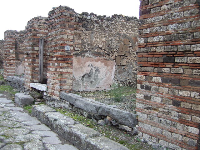 VII.10.4 Pompeii. December 2005. Looking east across shop. On the left at the rear can be seen a step and base of the steps to the upper floor.

