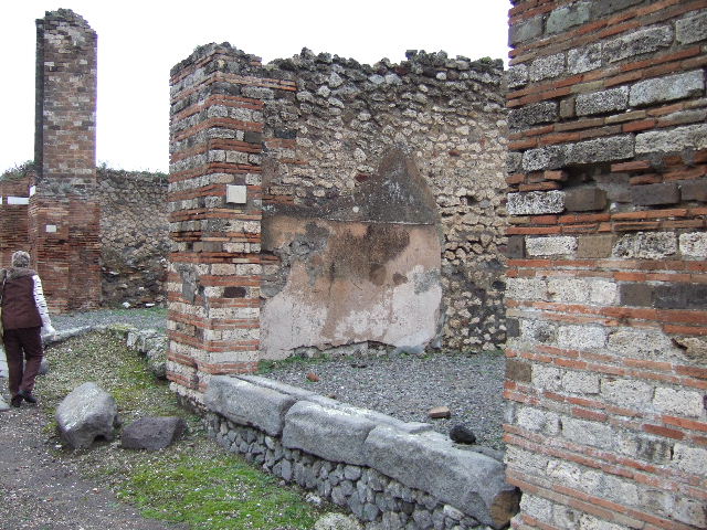 VII.10.6 Pompeii. December 2005. Looking east across shop towards doorway to rear room. In the north-east corner of the shop-room (on left) can be seen the remains of the base of steps to upper floor.