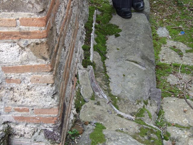 VII.10.9 Pompeii. March 2009. Lead pipe in pavement outside entrance, in Vicolo del Balcone Pensile.