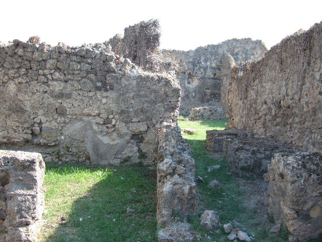 VII.12.13 Pompeii. September 2005. Niche on east wall near oven.
According to Boyce, on the wall of the room with the oven, near the hearth, was a lararium painting. Into the panel, near the top, was set a rectangular niche with projecting floor. The inside walls were coated with white stucco decorated with spots of many colours. On the wall on each side of it were the traces of the figure of a Lar. Below the niche a pediment was formed by bricks embedded in the wall. Within the pediment were painted a cock and a peacock, one above the other.
On the wall below the pediment were painted two serpents confronted at an altar. At the side of the altar stood Vesta, wearing a wreath of flowers. At her side stood an ass, its head appearing above the altar.
See Boyce G. K., 1937. Corpus of the Lararia of Pompeii. Rome: MAAR 14. (p.71, no.318)