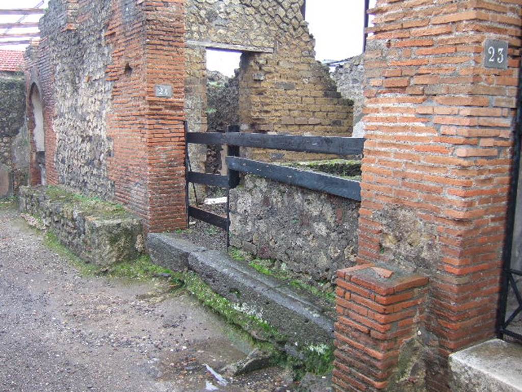 VIII.2.24 Pompeii. December 2004. Looking east to doorway, and bench outside. In the east wall of the bar can be seen a doorway, this led into the kitchen with hearth and latrine. See Eschebach, L., 1993.  Gebudeverzeichnis und Stadtplan der antiken Stadt Pompeji. Kln: Bhlau. (p.358)
