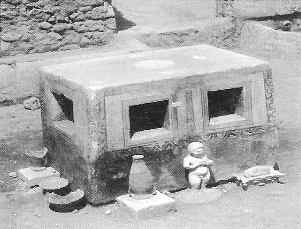 VIII.7.10 Pompeii. 1910. Detail of unusual masonry table to north of triclinium, with amphora, statuette and other objects.
According to PARP: PS (2005), this table is now totally destroyed.
See PARP: PS 2005 season report http://www.fastionline.org/docs/FOLDER-it-2005-48.pdf . (p. 3)
See Notizie degli Scavi di Antichit, 1910, p. 265-7, fig. 6.
