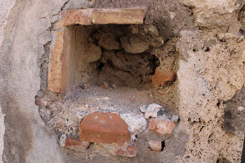 IX.2.21 Pompeii. December 2018. 
West side of entrance doorway, possible niche, or as described by Warscher a hole for barring the door. Photo courtesy of Aude Durand.

