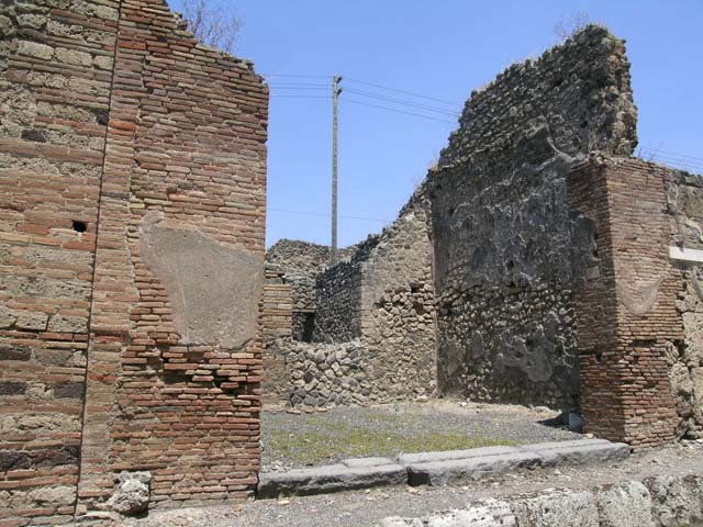 IX.3.13 Pompeii. March 2009.   North wall of caupona, with remains of stairs in north-west corner, and doorway to dwelling. On the west wall, on the left, under the stairs would have been a lararium painting, now disappeared.  Luckily both Fiorelli and Sogliano wrote a good description. 
Fiorelli told us that there was a Genius flanked by Lares, the caricature of a male head, and two gladiators in combat.  Sogliano reported that the painting was done in red monochrome on white plaster, and showed a Genius with patera and corncupocia, sacrificing at the altar in the middle of two Lares with rhyton and situla. 
See Pappalardo, U., 2001. La Descrizione di Pompei per Giuseppe Fiorelli (1875). Napoli: Massa Editore. (p. 146)
See Sogliano, A., 1879. Le pitture murali campane scoverte negli anni 1867-79. Napoli: (p.11)
See Boyce G. K., 1937. Corpus of the Lararia of Pompeii. Rome: MAAR 14. (p.83-4) 
See Jacobelli, L., 2003. Gladiators at Pompeii. Rome: L’Erma di Bretschneider. (p. 82)
