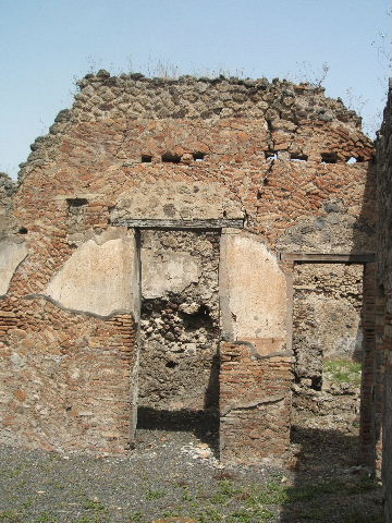 IX.6.3 Pompeii. May 2005. Doorway to kitchen area, looking south.
According to Boyce, on the east wall (not photographed) was a lararium painting, the upper part was damaged when found. An altar stood between the Genius on the right, and the tibicen on the left. On each side was a Lar with rhyton and situla standing between two shrubs. In the lower zone were two serpents confronted at an altar furnished with two eggs. See Boyce G. K., 1937. Corpus of the Lararia of Pompeii. Rome: MAAR 14. (p.86, no.428).  See Sogliano, A., 1879. Le pitture murali campane scoverte negli anni 1867-79. Napoli: (p.12, no. 25) According to Giacobello, today the painting has been totally lost.
See Giacobello, F., 2008. Larari Pompeiani: Iconografia e culto dei Lari in ambito domestico.  Milano: LED Edizioni. (p.209)

