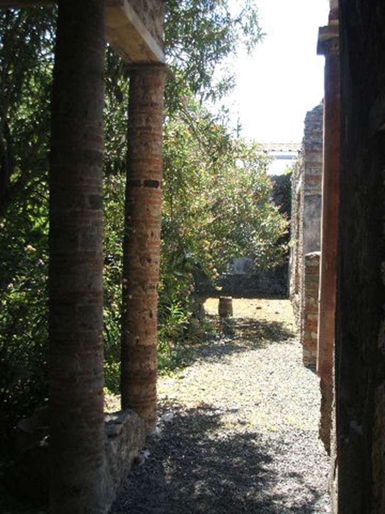IX.7.20 Pompeii. May 2005. Looking south along west portico. The two columns at the rear of the atrium, leading into the peristyle can be seen on the right.

