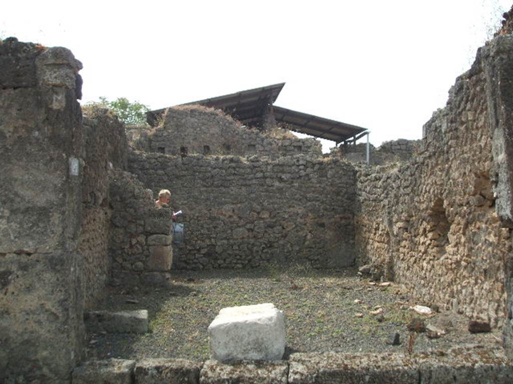 IX.7.23 Pompeii. May 2005. Looking south across caupona to narrow rear room. According to Mau, immediately behind the threshold of the main room, lay a large stone square block of travertine (0.90 long, 0.58 wide and 0.46 high). He thought this probably served as the base for a wooden table, around which the customers would settle down to eat. He also said the threshold of this main room seemed to have been made of wood. See Mau in BdI, 1882, (p.183)
According to Eschebach, the podium used to be on the west side (right of photo) of the caupona, the rear room had the hearth and a window looking into the caupona. See Eschebach, L., 1993. Gebudeverzeichnis und Stadtplan der antiken Stadt Pompeji. Kln: Bhlau. (p.435)

According to Della Corte, this caupona was attributed to Ti. Claudio Epafrodito, because of the seal/signet brought to light here 
Ti. C(laudius) Ep(aphroditus)    [CIL X 8058,9]. 
He was well noted as producer of wine, one of his numerous named amphora was found in an adjacent atrium.  See Della Corte, M., 1965.  Case ed Abitanti di Pompei. Napoli: Fausto Fiorentino. (S.27 on p.197)
