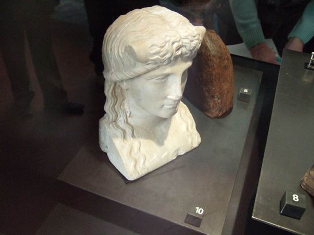 Marble statuette of Iside-Io? Found in IX.7.23, according to Naples Museum card.  Now in Naples Archaeological Museum.  Inventory number 119584. According to Jashemski and Dwyer, this was found in the atrium of IX.7.20, but probably belonged to the peristyle. It was discovered on 28th October 1880, and described as 
Bust for a herm. White marble. Height m.0.21.
The back of the bust is flat and the sides show cuttings for cross-bars.
A river god, with bulls horns protruding from above temples.
Hair parted down the middle, descends in wavy tresses to chest.
See Jashemski, W. F., 1993. The Gardens of Pompeii, Volume II: Appendices. New York: Caratzas. (p.241)
See Dwyer, Pompeian Domestic Sculpture, pp.71-78.

