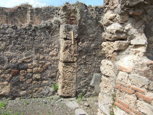 IX.9.6 Pompeii. May 2006. Arched lararium niche with white stucco walls in west wall of portico, with masonry altar built under it. According to Boyce a coin of Claudius was found on the floor of the niche. See Boyce G. K., 1937. Corpus of the Lararia of Pompeii. Rome: MAAR 14. (p.91)
